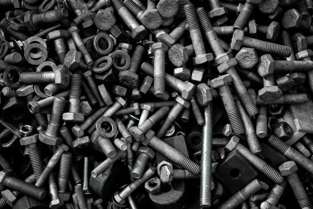 Heap of assorted industrial bolts, screws and nuts in different sizes and finishes