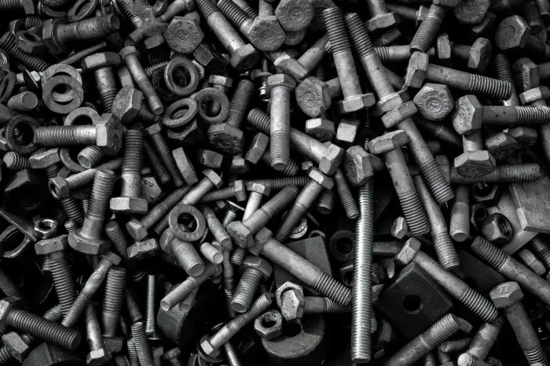Heap of assorted industrial bolts, screws and nuts in different sizes and finishes