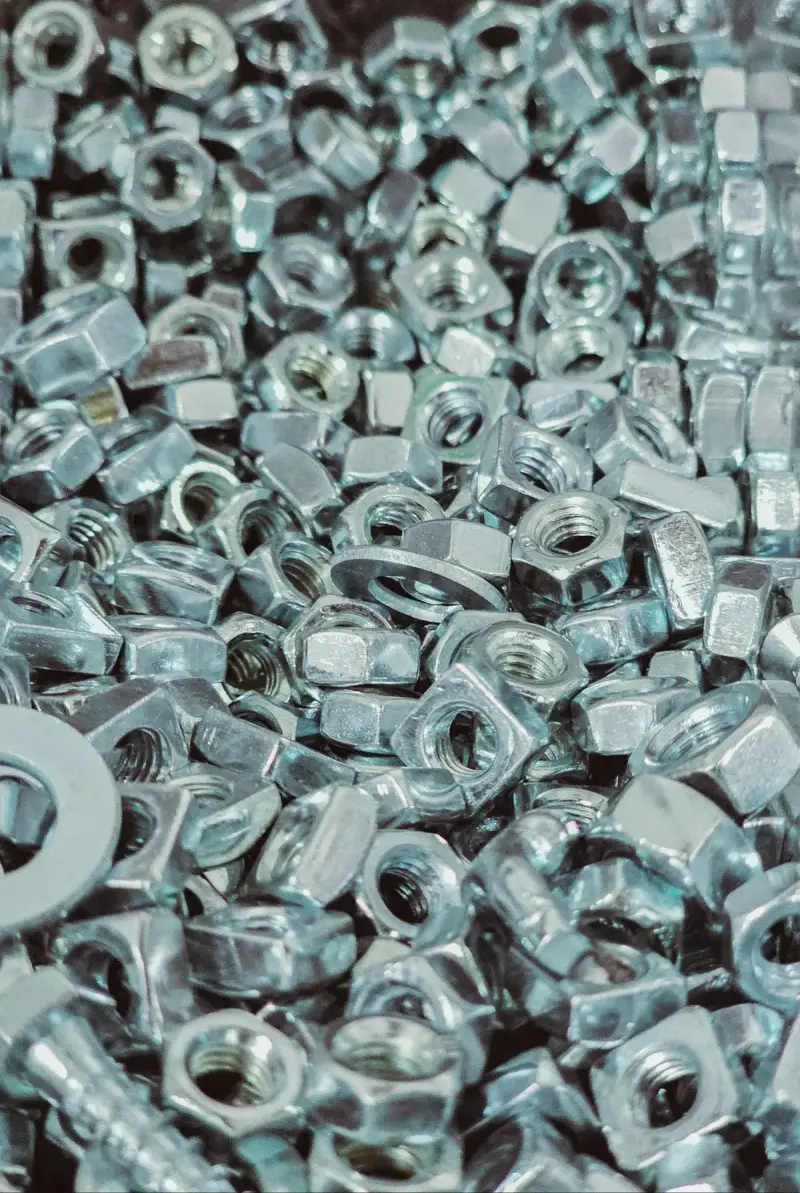 Close-up of a pile of silver metal nuts and bolts
