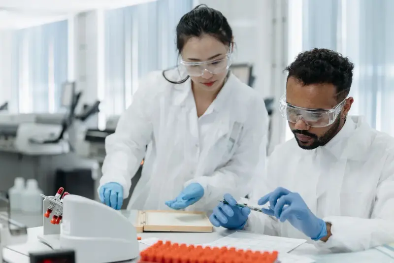 Two scientists in lab coats examining samples together