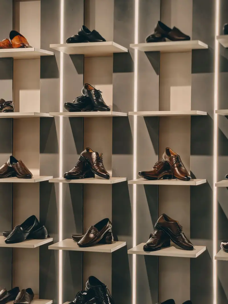 Brown men's dress shoes displayed on modern shelves