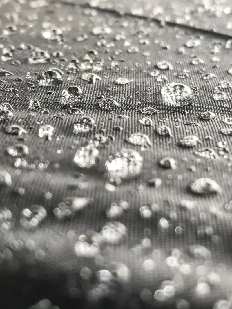 Water beading on gray waterproof fabric in close-up