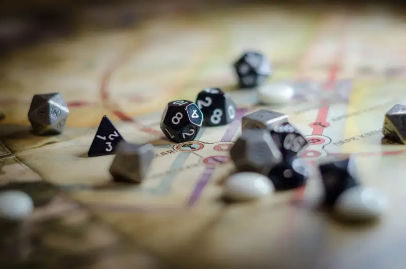 Black and silver polyhedral dice scattered across a role-playing game map