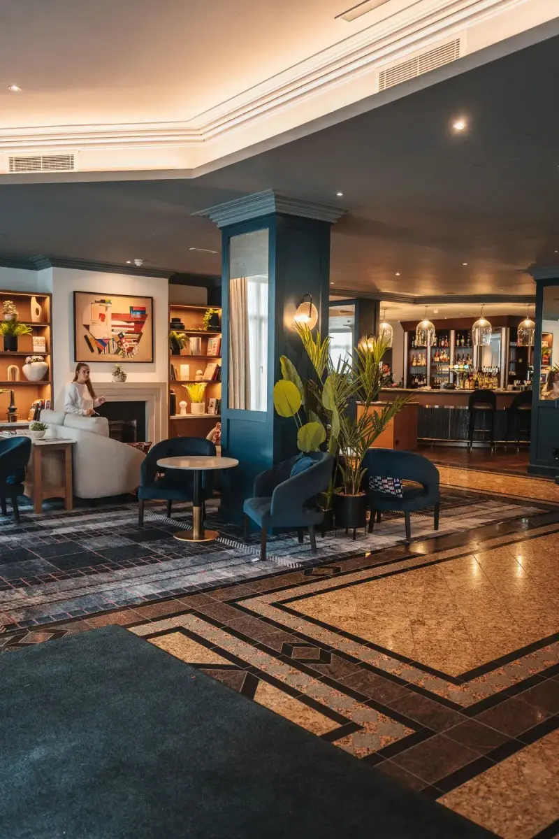 Modern hotel lounge with upholstered seating, artwork and warm lighting