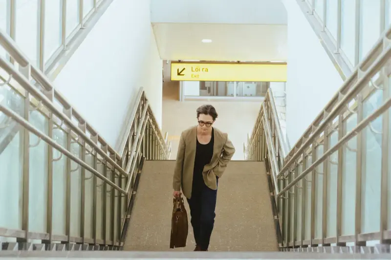 Businesswoman carrying a briefcase while climbing stairs inside an airport