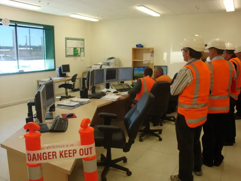 Control room of a 100 MW geothermal power plant with operator workstations and screens