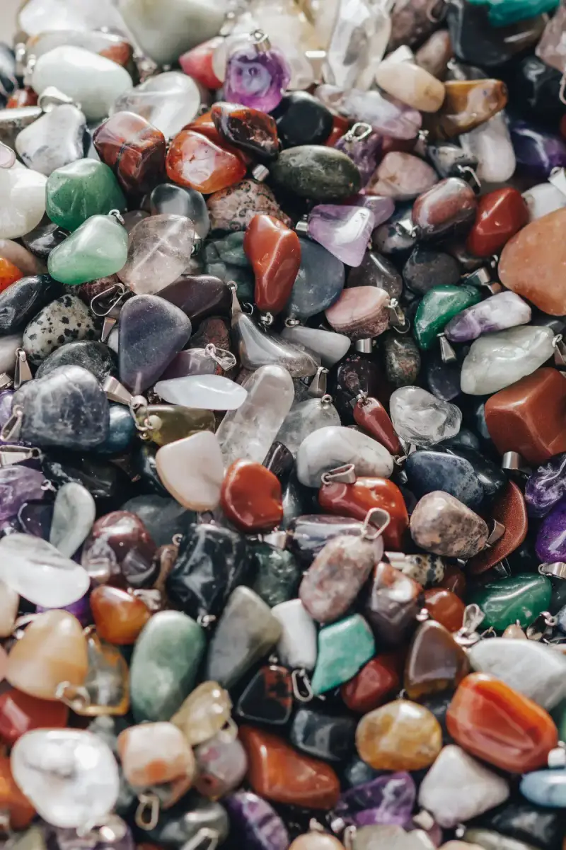 Heap of polished gemstone pendants in jasper, quartz, amethyst and agate