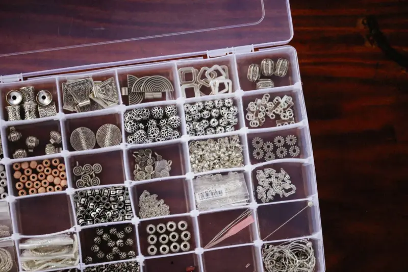 Organizer box of silver findings, spacer beads and charms in compartments