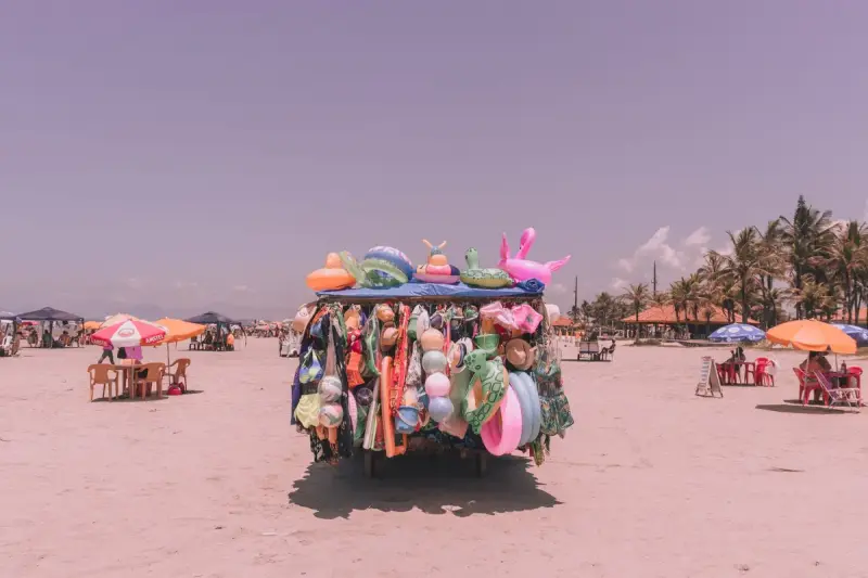 Beach shop on the sand with inflatable toys and swim accessories under palm trees