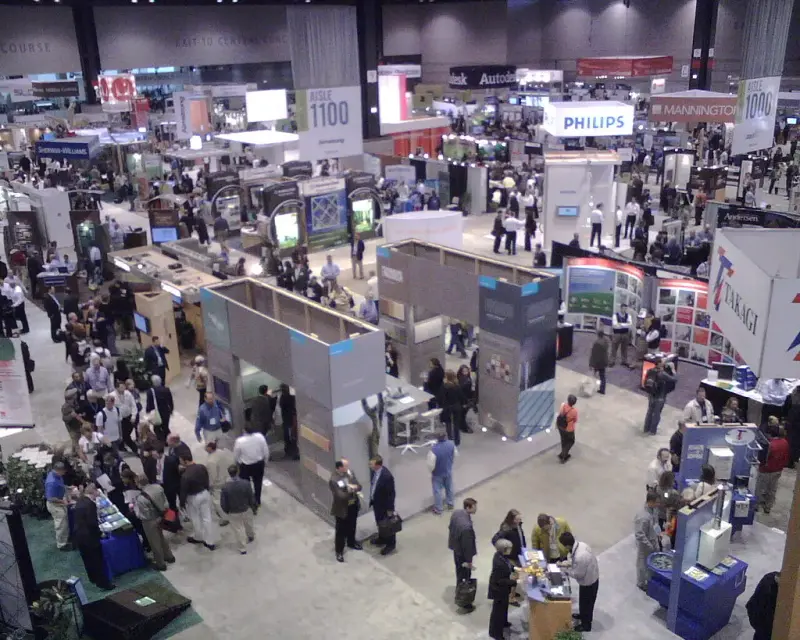 Overhead view of the busy Greenbuild Expo hall with aisle 1100 banner, booths and visitors