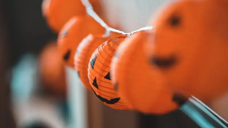 Close-up of orange pumpkin lanterns strung with lights