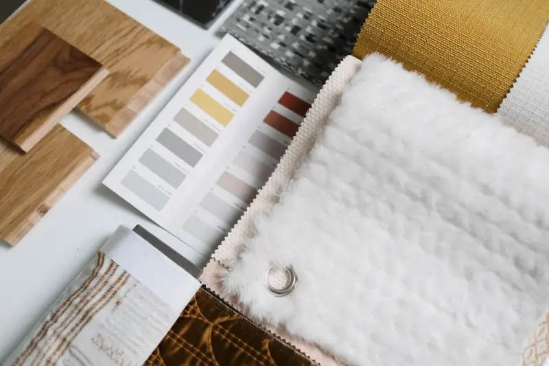 Flat lay of fabric samples and color swatches for an interior design scheme