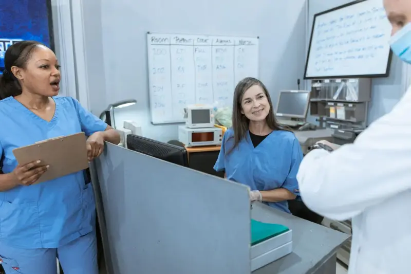 Doctor and nurses talking together at a hospital reception counter