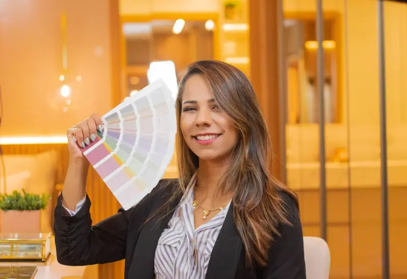 Smiling professional woman in a black blazer holding color swatches