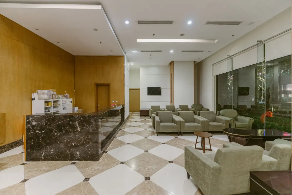 Spacious hotel lobby with a marble reception desk and contemporary seating