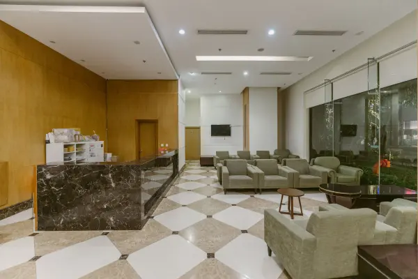 Spacious hotel lobby with a marble reception desk and contemporary seating