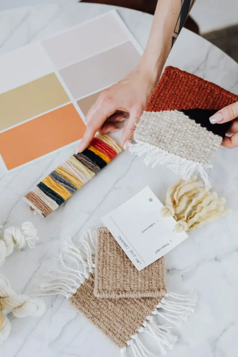 Designer comparing textile and paint samples on a work surface