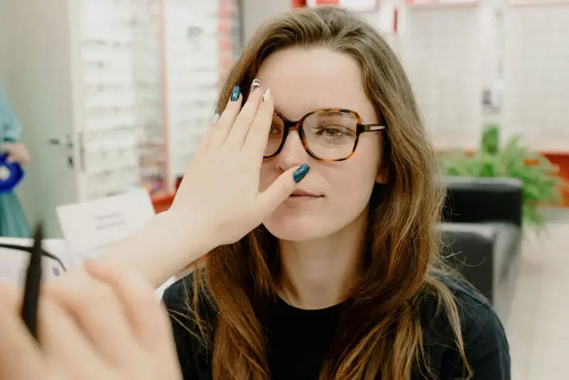 Young woman covering one eye during a vision test in an optical store