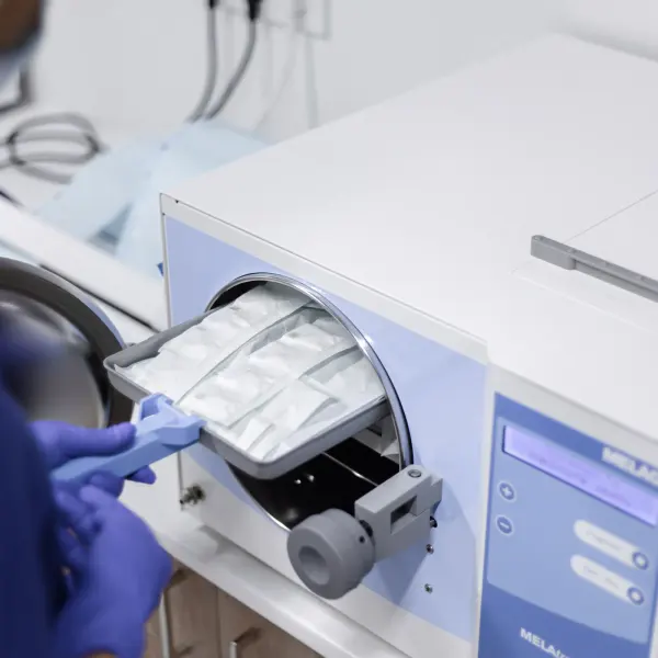A healthcare worker operating an autoclave