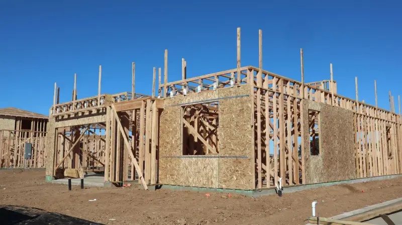 Timber frame of a two-story house under construction on a sunny day