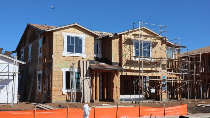 Two-story house under construction with scaffolding and an unfinished exterior