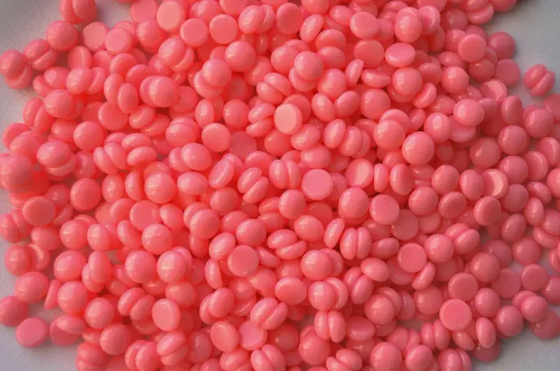 Close-up of pink hard wax beads used for professional hair removal