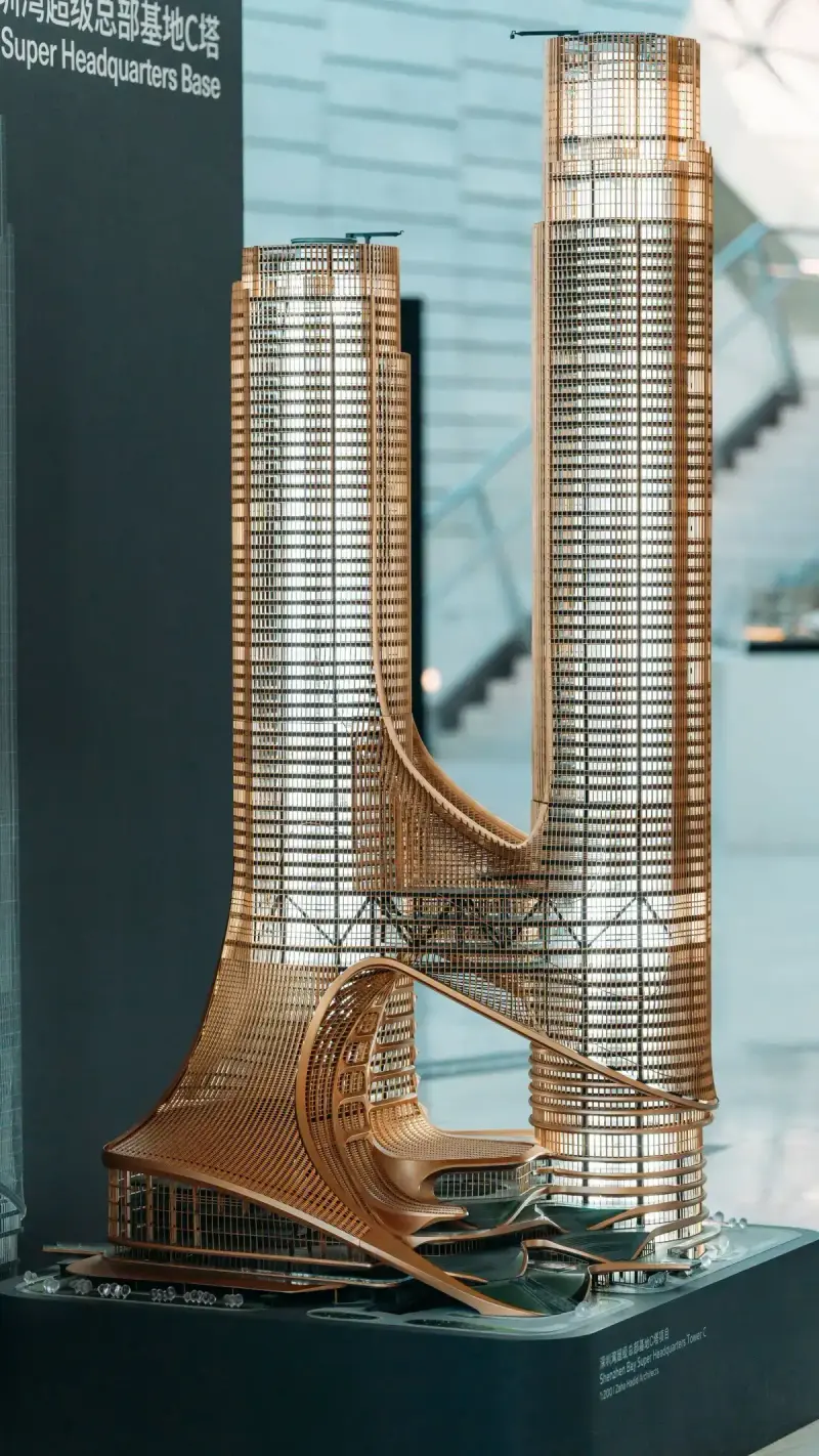Architectural scale model displayed on a plinth inside a gallery