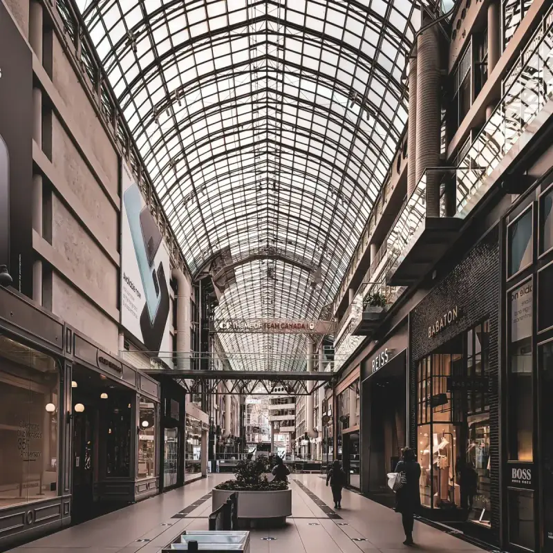 Shopping mall interior beneath a broad glass ceiling