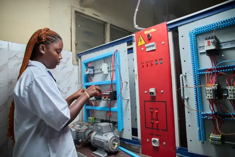Technician working on an electrical control panel; electrical systems reference.