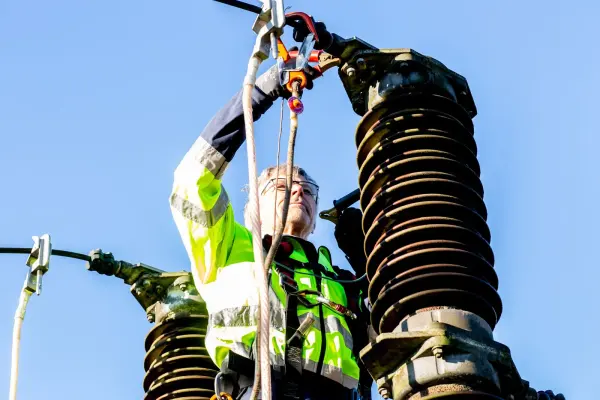 Utility worker inspecting power infrastructure; electrical