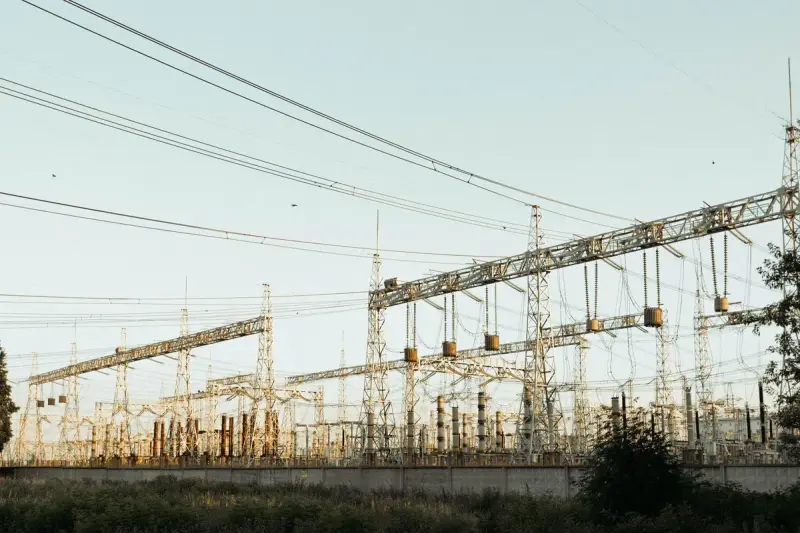 Wide view of an electrical substation with towers and lines
