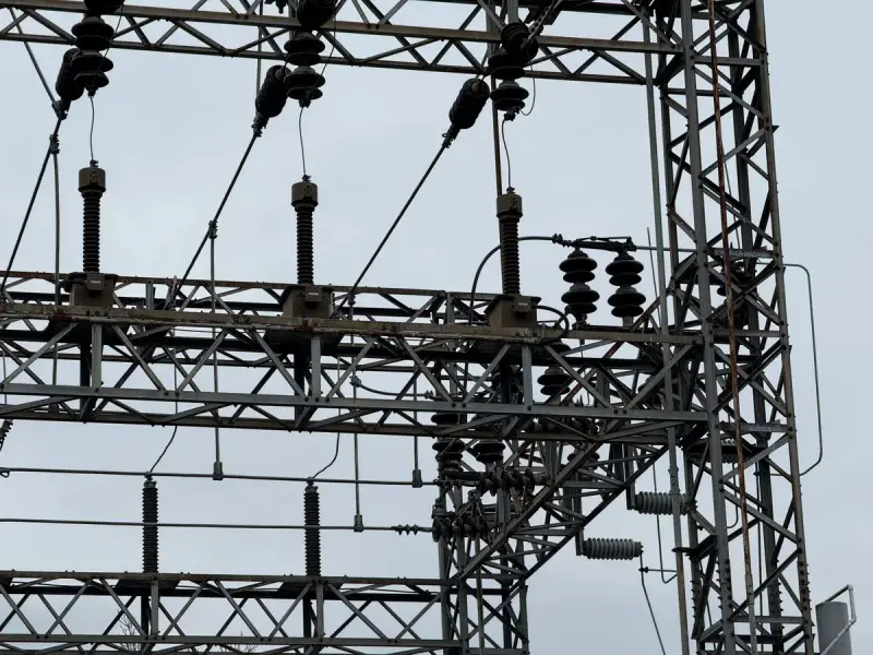 High-voltage line hardware against a cloudy sky