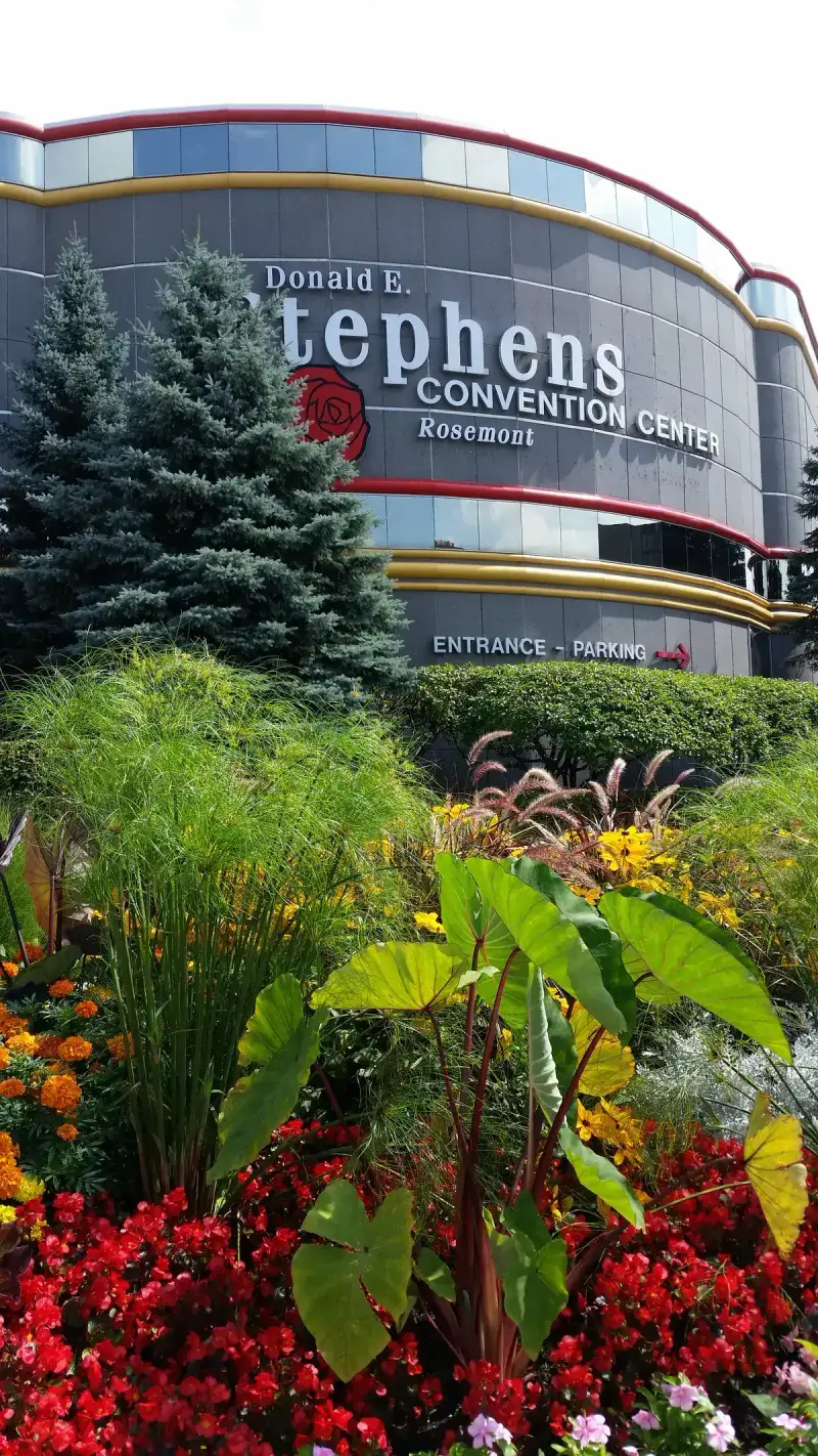Donald E. Stephens Convention Center facade in Rosemont, Illinois, behind red flower beds