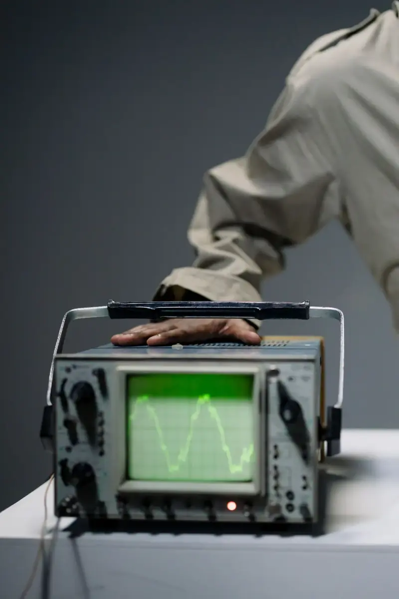 Hand resting on an instrument with a green waveform on its screen