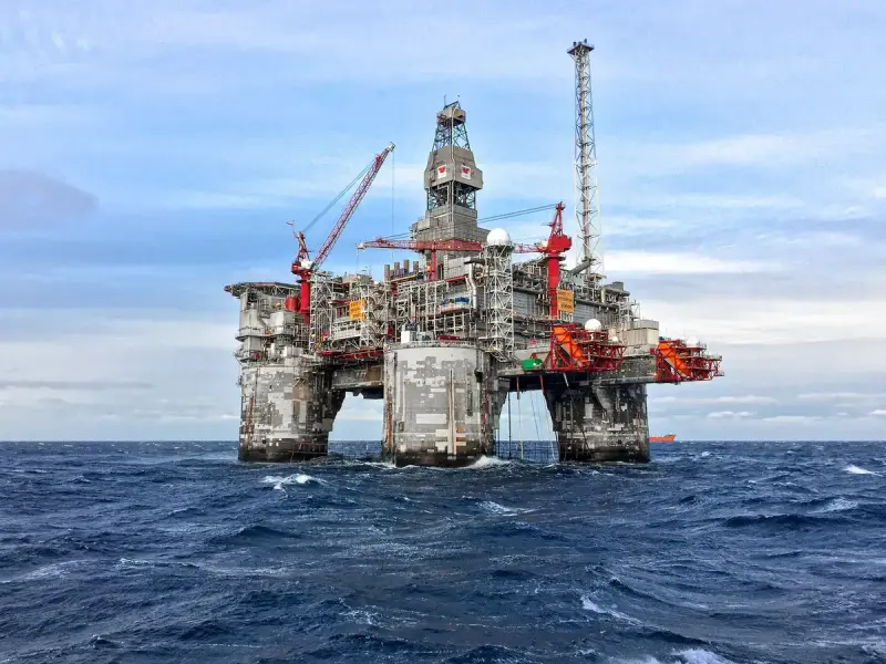 Offshore oil platform standing in the North Sea under a clear blue sky