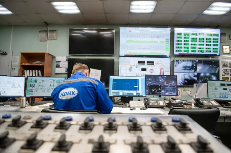 Engineer monitoring multiple data screens in an industrial control room