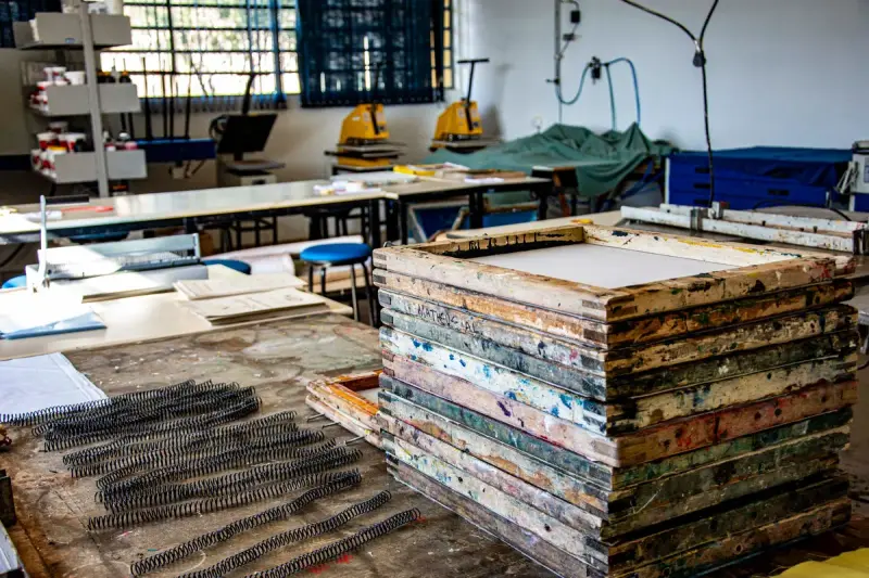 Textile workshop with stacks of used screen printing frames and long print tables