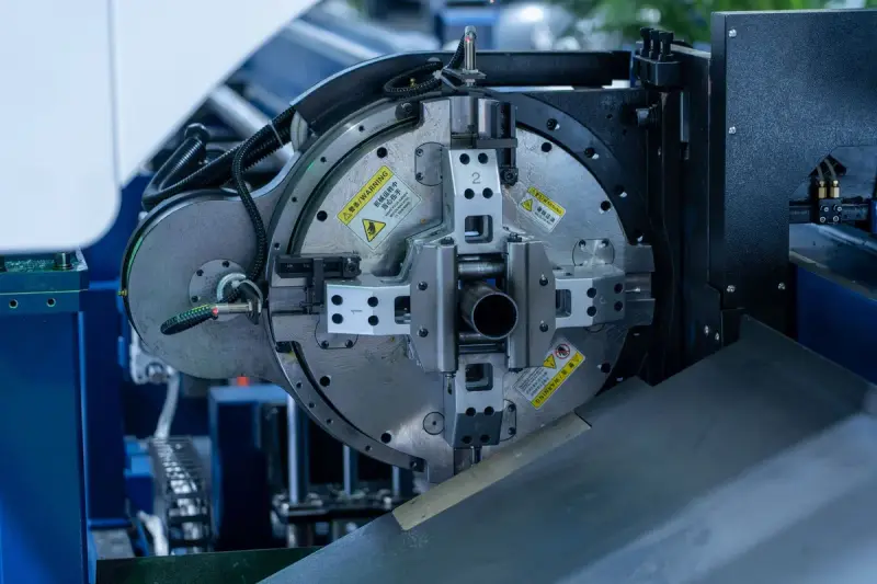 Close-up of the rotary chuck and jaws on a CNC tube processing machine