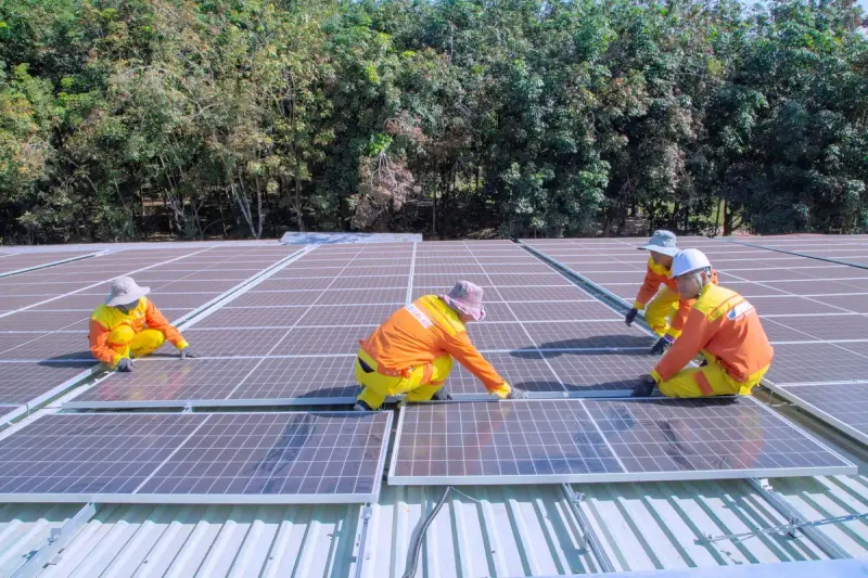 Team of workers installing solar panels on a sunny day
