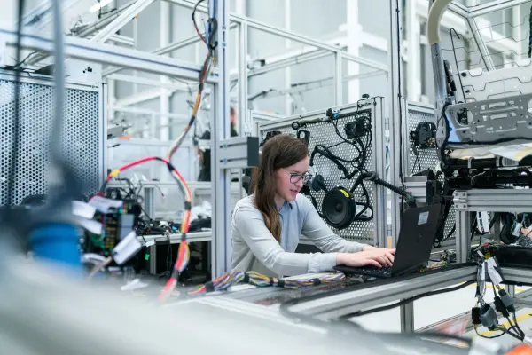 Female engineer working on a laptop beside technical equipment in a laboratory