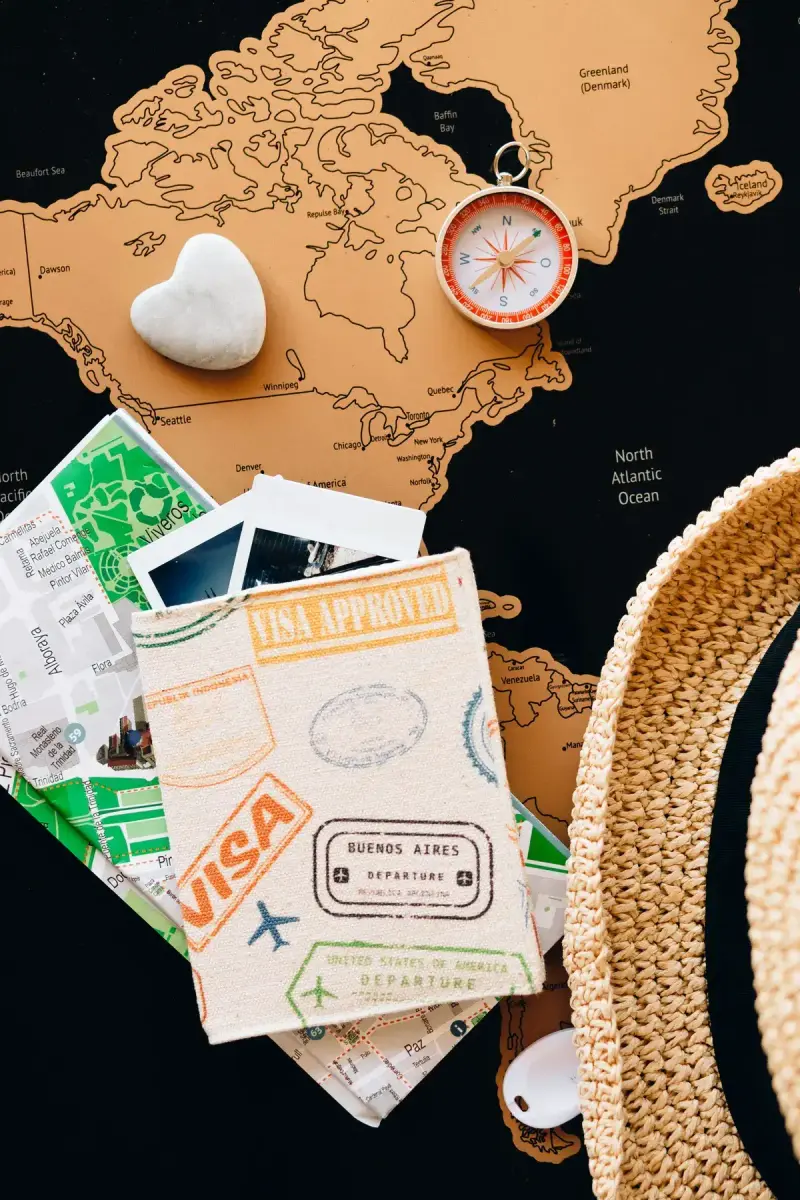 Passport and compass resting on printed travel maps