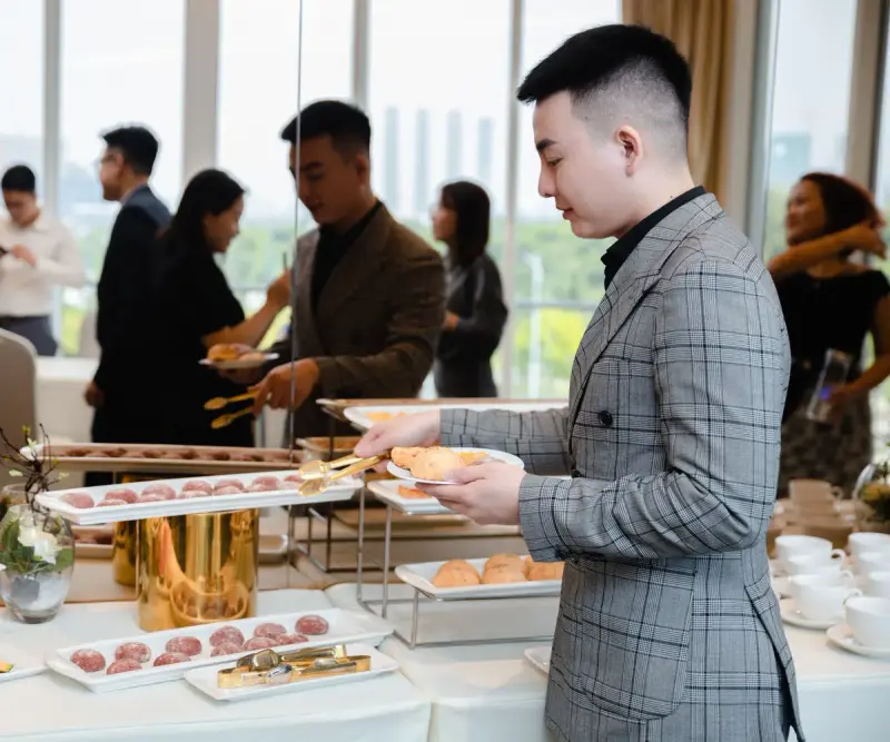 Conference attendees serving themselves at a breakfast buffet