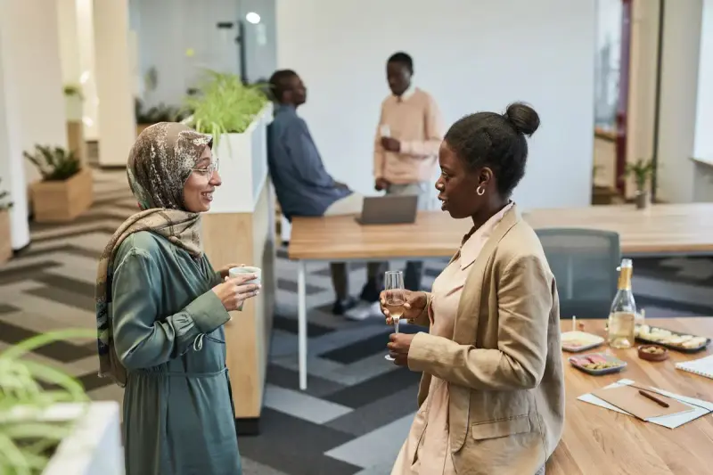 Two women talking over drinks at a reception