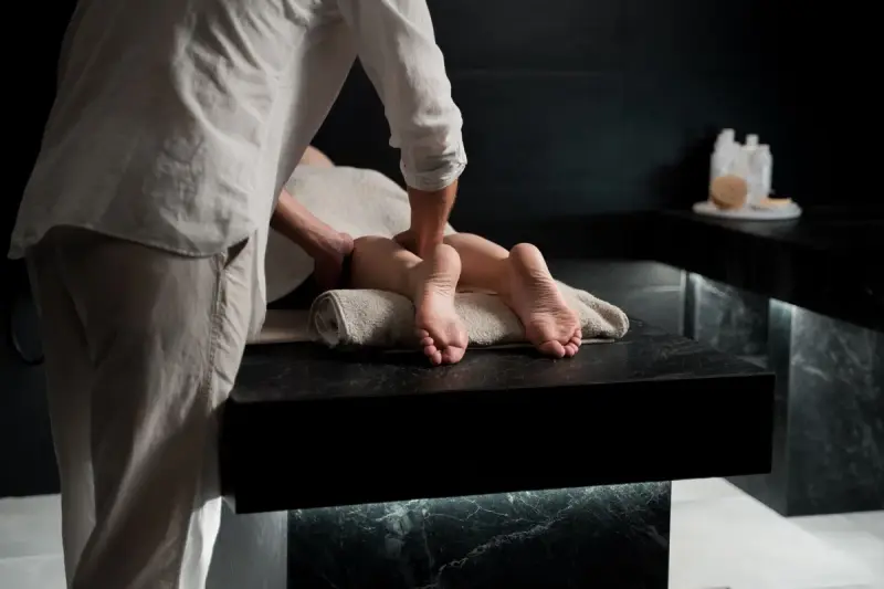 Therapist giving a foot massage in a modern spa treatment room
