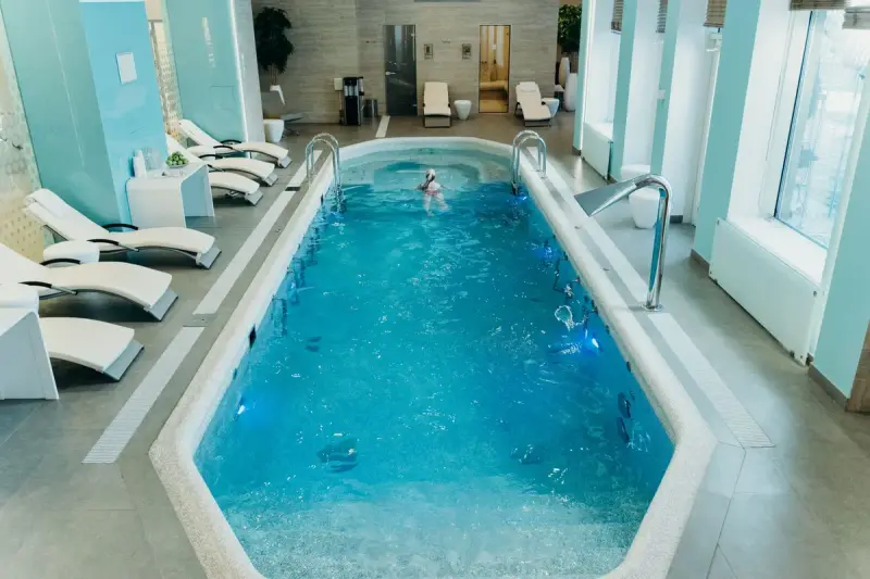 Bright indoor spa pool with lounge chairs and a calm atmosphere