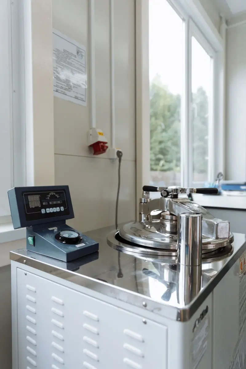 Stainless steel laboratory process equipment beside a bright window