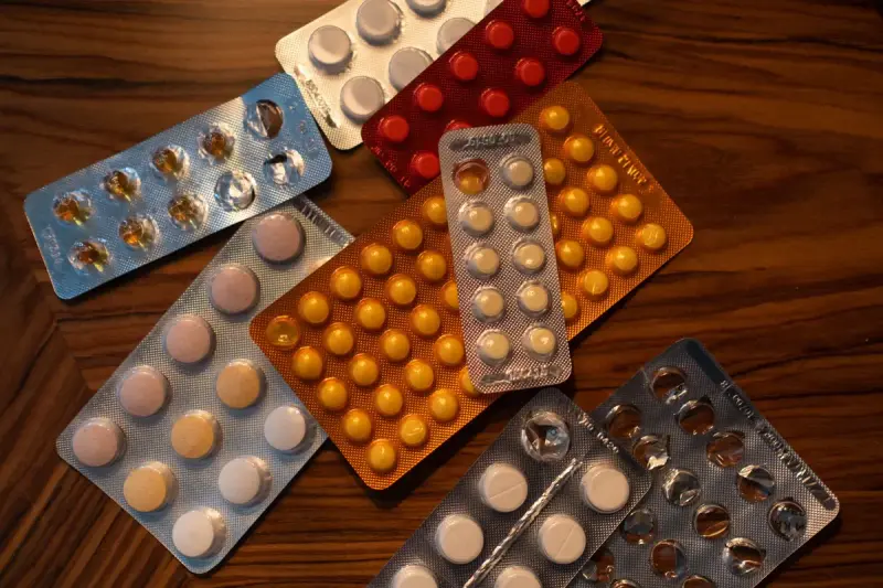 Colorful blister packs of tablets spread on a wooden table