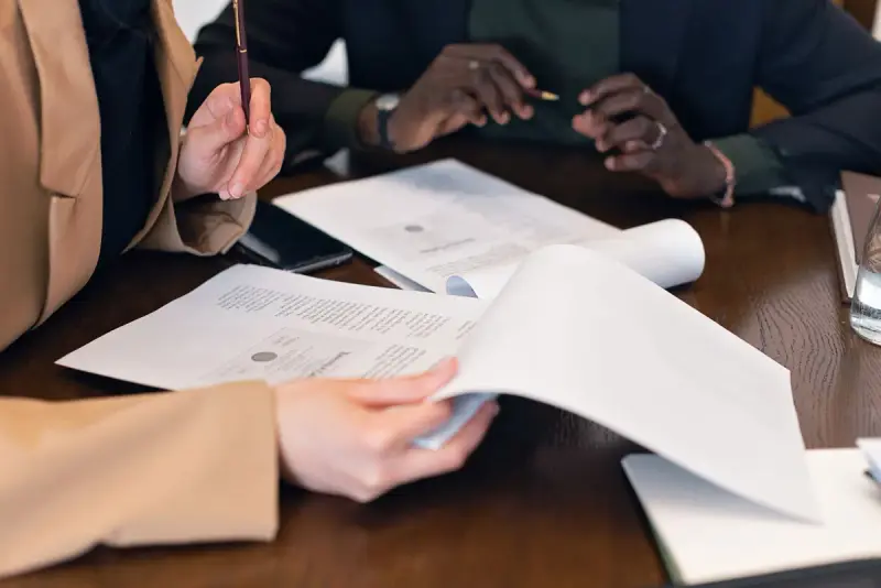 Close-up of professionals reviewing documents during a meeting