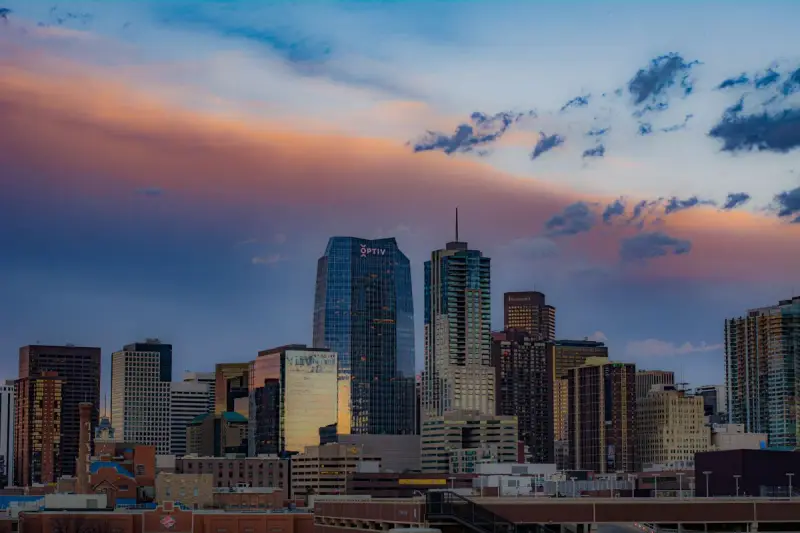 Downtown Denver skyscrapers under a colorful sunset sky