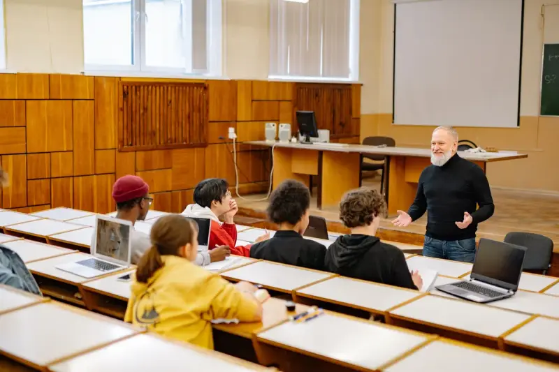 University students and a professor using technology in a lecture hall
